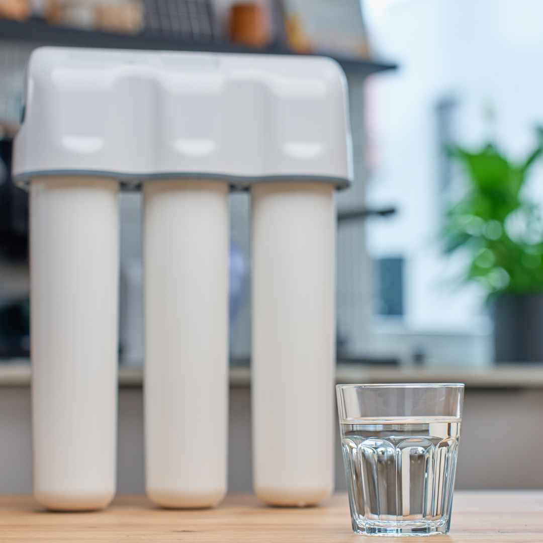 Image of a water purifier next to a clean glass of water