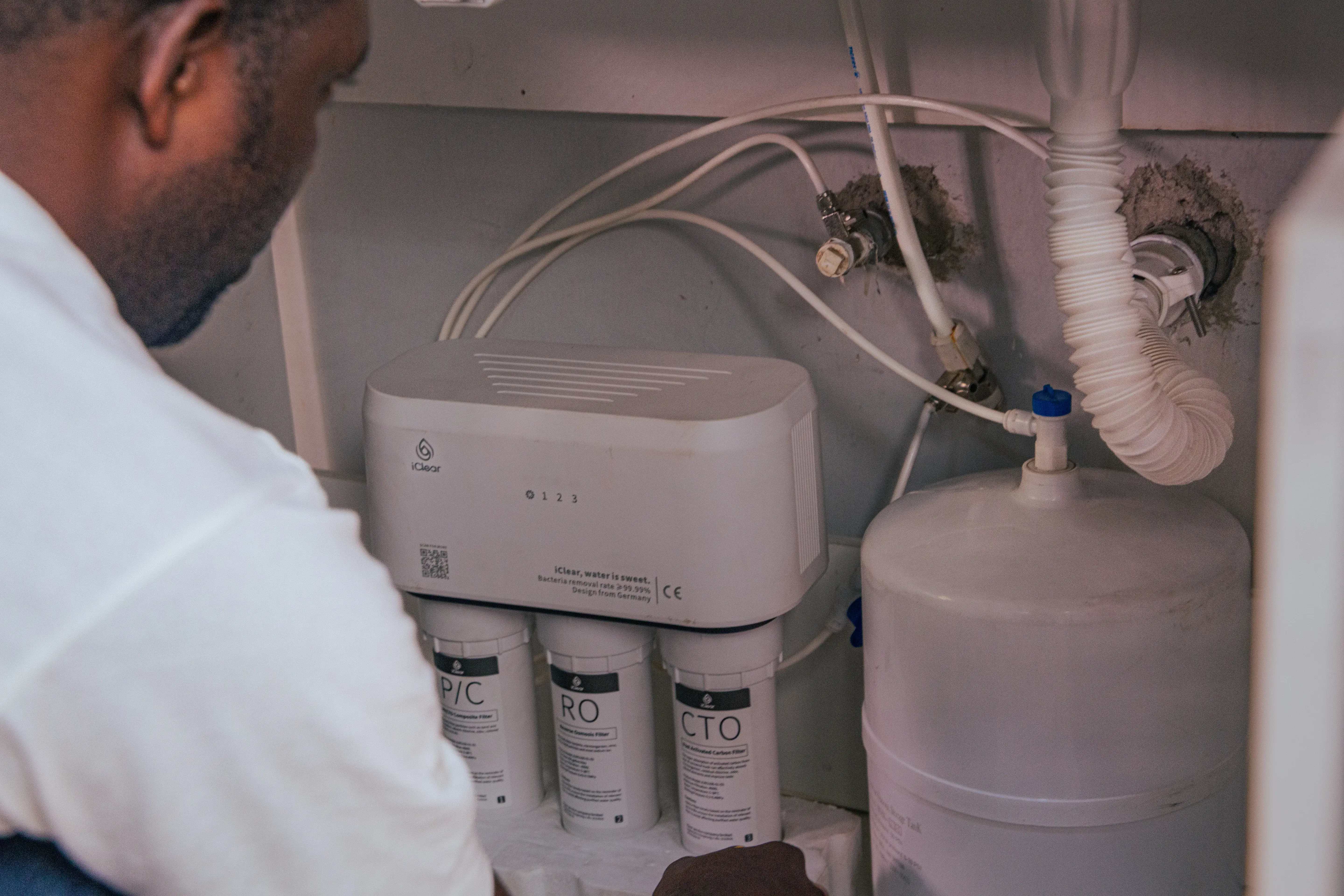 An iClear employee installing a reverse osmosis water purifier