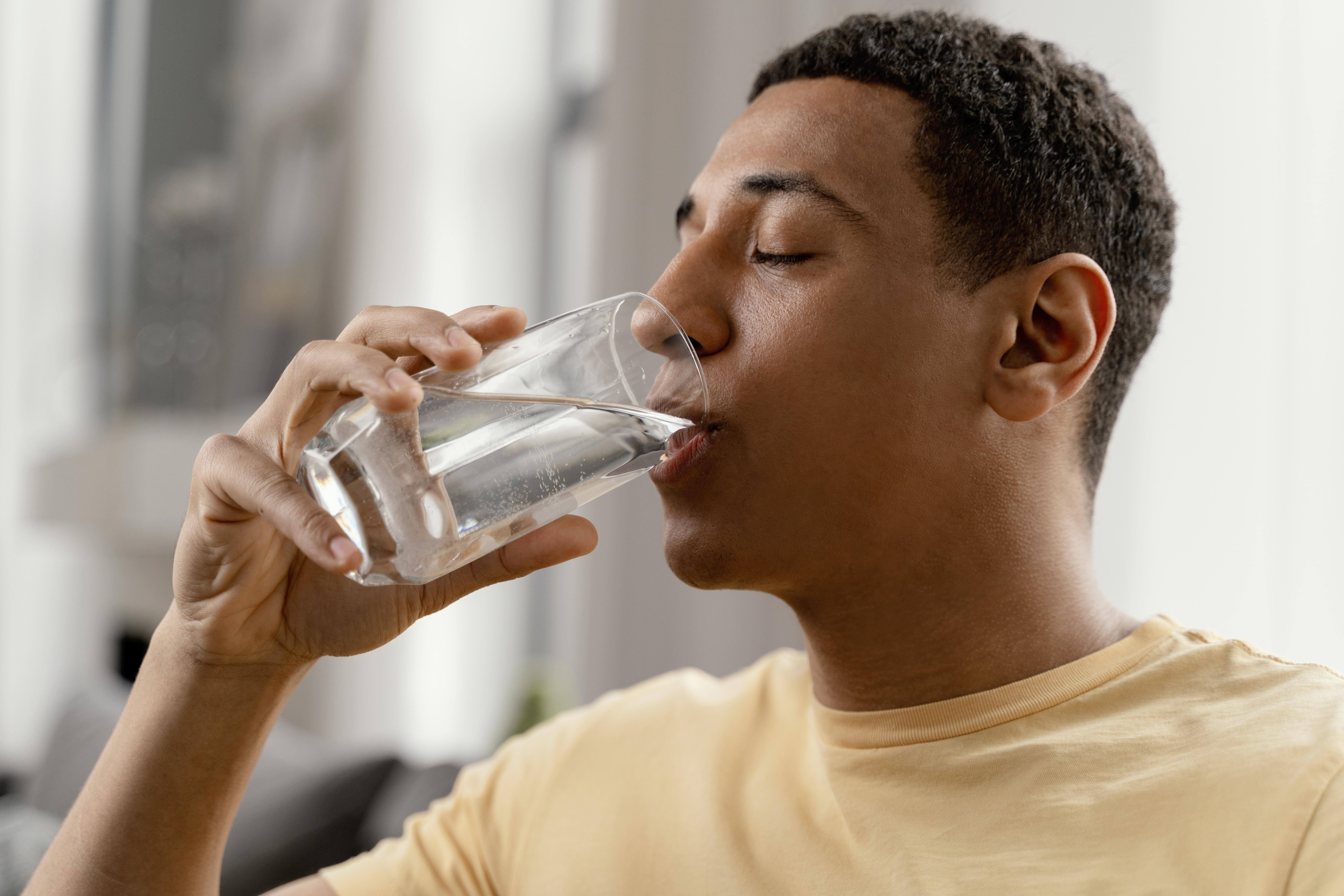 Image of a man drinking purified water from a water purifier